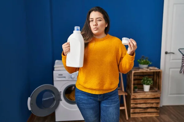 Young Hispanic Woman Holding Detergent Bottle Winking Looking Camera Sexy — Fotografia de Stock