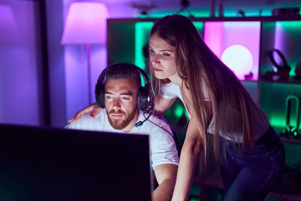 stock image Young couple playing video games relaxed with serious expression on face. simple and natural looking at the camera. 