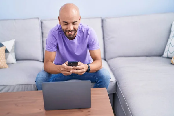 Young Bald Man Using Smartphone Laptop Home — Stockfoto
