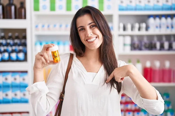 Молодая Брюнетка Покупает Аптеке Таблетки Показывая Пальцем Себя Улыбаясь Счастливой — стоковое фото