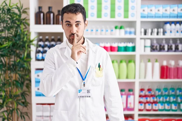 Handsome Hispanic Man Working Pharmacy Drugstore Asking Quiet Finger Lips — Fotografia de Stock