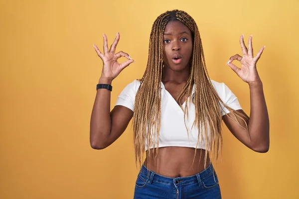 African American Woman Braided Hair Standing Yellow Background Looking Surprised — Photo