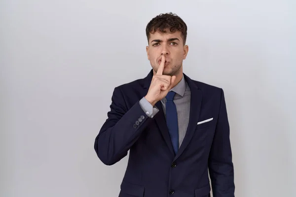Young Hispanic Business Man Wearing Suit Tie Asking Quiet Finger — Stockfoto