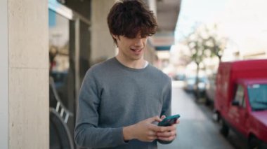 Sokakta akıllı telefon kullanan, kendine güvenen genç bir İspanyol.