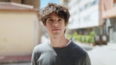 Sokakta kendinden emin gülümseyen İspanyol genç adam.