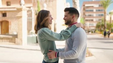 Young couple kissing and hugging each other standing at street