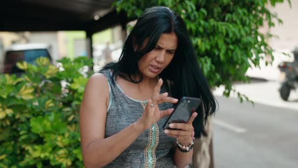 Střední Věk Hispánská Žena Pomocí Smartphone Vítězným Výrazem Ulici — Stock video