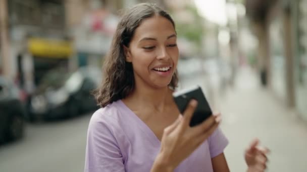 若いアフリカ系アメリカ人女性が路上で勝者の表情でスマートフォンで話しています — ストック動画