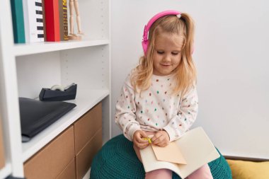 Kütüphane okulunda müzik okuyan sevimli sarışın kız öğrenci.
