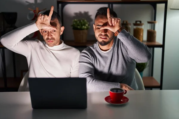 Homosexual Couple Using Computer Laptop Making Fun People Fingers Forehead — Stockfoto