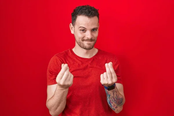 Young Hispanic Man Standing Red Background Doing Money Gesture Hands — Stockfoto