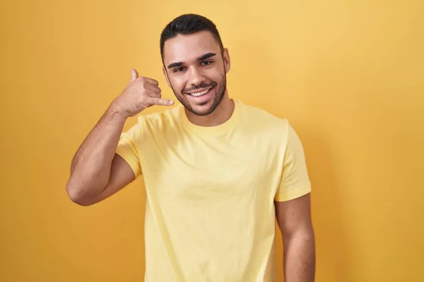 Young Hispanic Man Standing Yellow Background Smiling Doing Phone Gesture — Fotografia de Stock