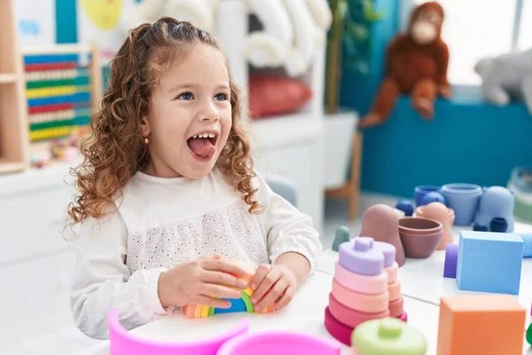 stock image Adorable blonde toddler playing with toys sitting on table at kindergarten