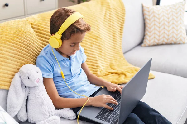 Adorable Hispanic Boy Using Laptop Headphones Sitting Sofa Home — Fotografia de Stock