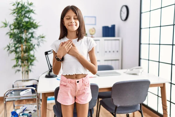 Young Hispanic Girl Standing Pediatrician Clinic Smiling Hands Chest Closed — Stock Photo, Image