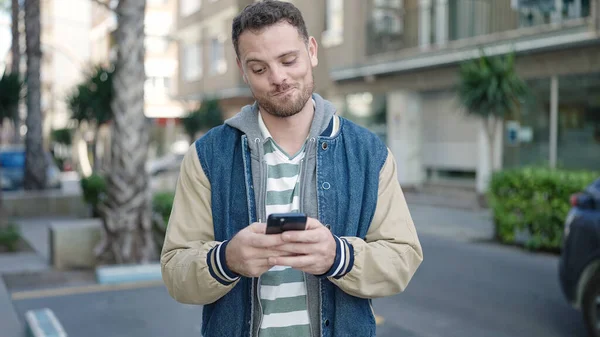 Young Caucasian Man Smiling Using Smartphone Street —  Fotos de Stock
