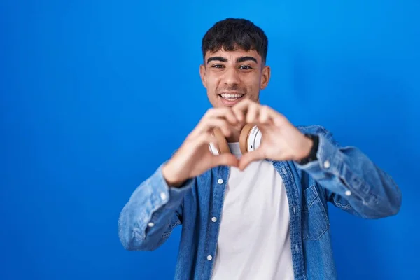 Homem Hispânico Jovem Sobre Fundo Azul Sorrindo Amor Fazendo Forma — Fotografia de Stock