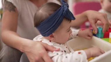 Anaokulunda dikilmiş plastik inşaat bloklarını emen sevimli çocuk.