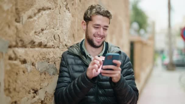 年轻人在街上用智能手机充满自信地微笑 — 图库视频影像