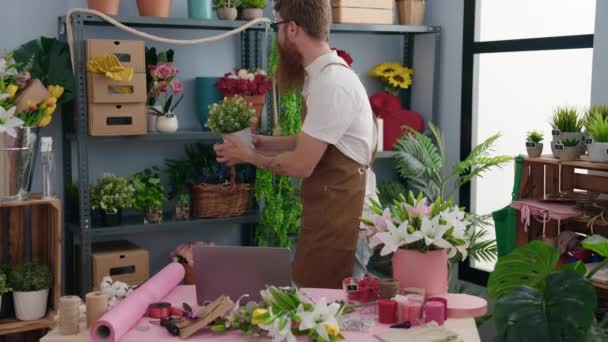 Young Redhead Man Florist Using Laptop Holding Plant Flower Shop — Stock video