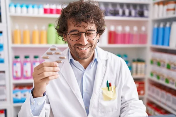 Молодий Іспаномовний Чоловік Фармацевт Посміхається Впевнено Тримає Таблетки Таблетки Аптеці — стокове фото