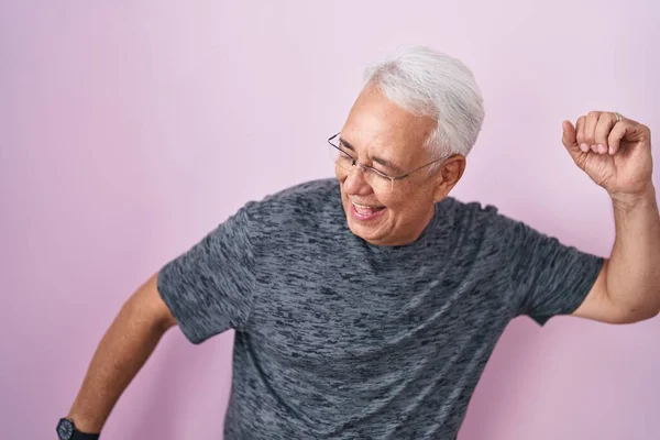 Мужчина Среднего Возраста Седыми Волосами Стоящими Розовом Фоне Танцующий Счастливый — стоковое фото