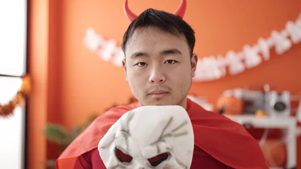 Young Chinese Man Wearing Devil Costume Holding Skull Mask Home — Stok fotoğraf