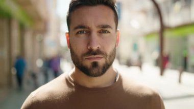 Sokakta kendinden emin gülümseyen İspanyol genç adam.