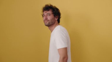 Young hispanic man standing with arms crossed gesture over isolated yellow background