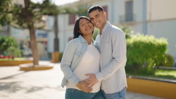 年轻的拉丁夫妇站在公园里 自信地微笑着 摸着肚子 — 图库视频影像