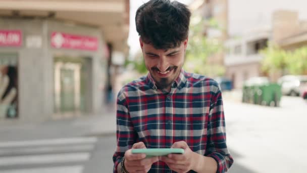 Młody Latynos Uśmiecha Się Pewnie Oglądając Wideo Smartfonie Ulicy — Wideo stockowe