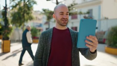 Young bald man smiling confident having video call at park