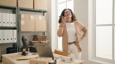 Middle age woman ecommerce business worker talking on the smartphone at office