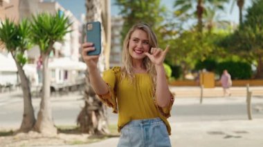Young woman smiling confident making selfie by the smartphone at street