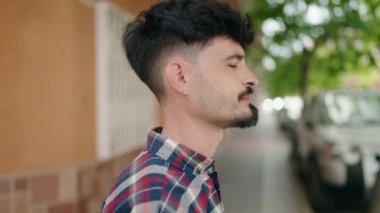 Sokakta kendinden emin gülümseyen İspanyol genç adam.