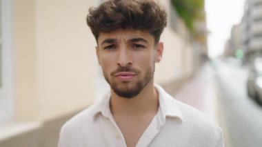 Young arab man smiling confident wearing glasses at street
