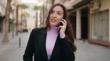 Genç İspanyol kadın gülümsüyor. Kendine güveniyor. Akıllı telefondan konuşuyor.