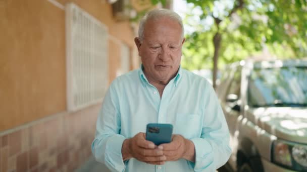 Senior Hombre Pelo Gris Sonriendo Confiado Usando Teléfono Inteligente Calle — Vídeos de Stock