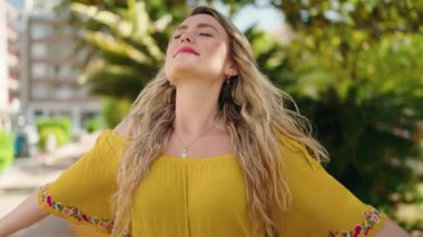 Young woman smiling confident breathing at park