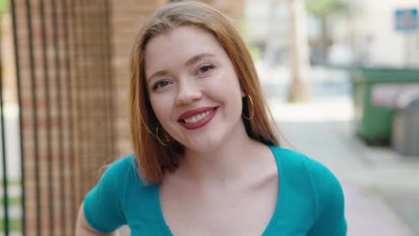 Νεαρή Κοκκινομάλλα Γυναίκα Χαμογελά Αυτοπεποίθηση Στέκεται Στο Δρόμο — Αρχείο Βίντεο
