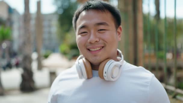 Young Chinese Man Smiling Confident Wearing Headphones Street — ストック動画