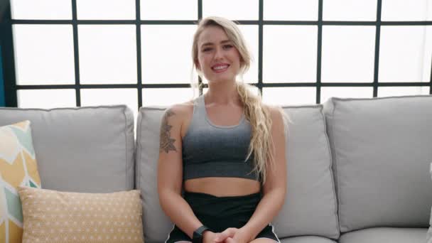 Young Blonde Woman Wearing Sportswear Sitting Sofa Home — Vídeos de Stock