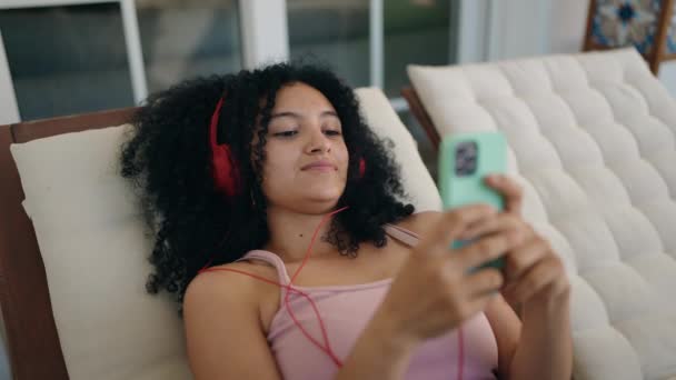 Jonge Spaanse Vrouw Luisteren Naar Muziek Liggend Dek Stoel Thuis — Stockvideo