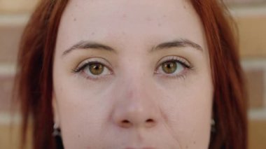 Young beautiful plus size woman standing with serious expression over isolated brick background
