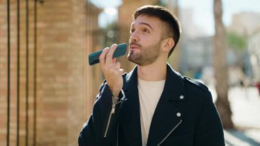Genç İspanyol adam gülümsüyor. Kendine güveniyor. Sokakta akıllı telefondan konuşuyor.
