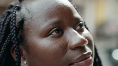 African american woman looking to the sky with relaxed expression at street