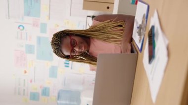 African american woman business worker using laptop working vertical video at office