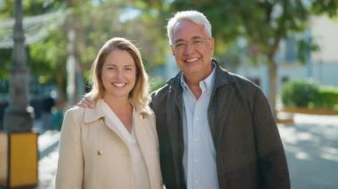 Middle age couple couple smiling confident hugging each other at park