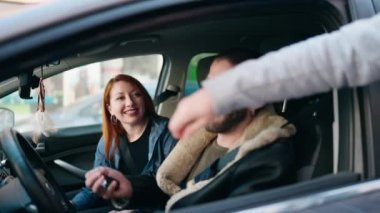 Man and woman couple holding key of new car at street