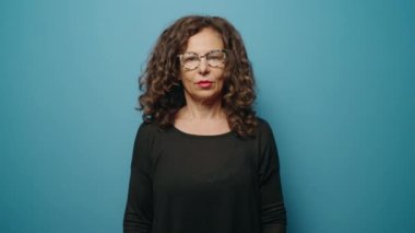 Middle age woman smiling confident standing with arms crossed gesture over blue background